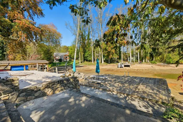 a front view of a house with garden and trees