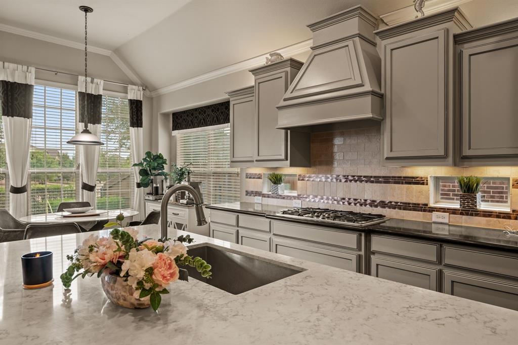 616 Whitetail Road Euless, TX 76039 - Photo 13 of 39 Kitchen featuring gray cabinetry, tasteful backsplash, decorative light fixtures, dark stone counters, and lofted ceiling