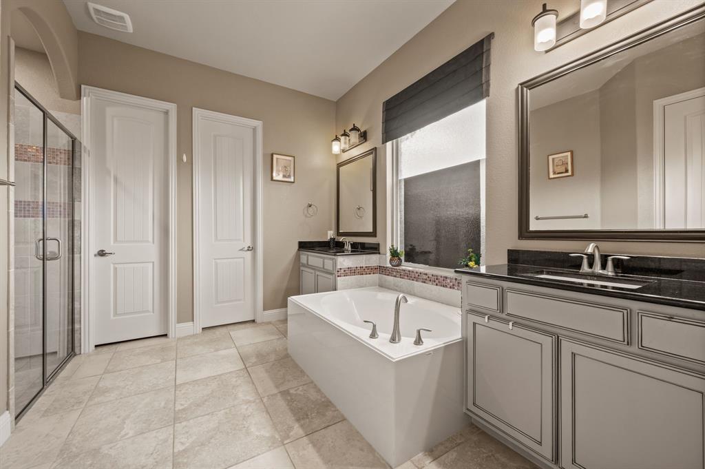 616 Whitetail Road Euless, TX 76039 - Photo 18 of 39 Bathroom with two vanities, a shower stall, a bath, and light tile patterned flooring