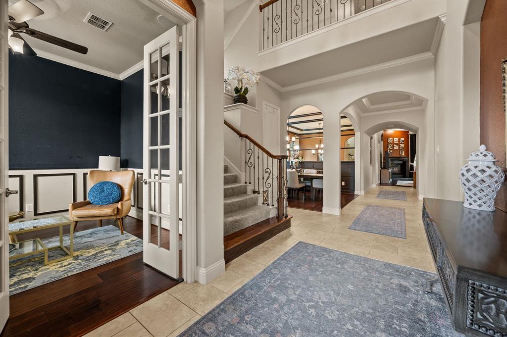 616 Whitetail Road Euless, TX 76039 - Photo 6 of 39 Entrance foyer featuring crown molding, stairway, light tile patterned floors, arched walkways, and french doors