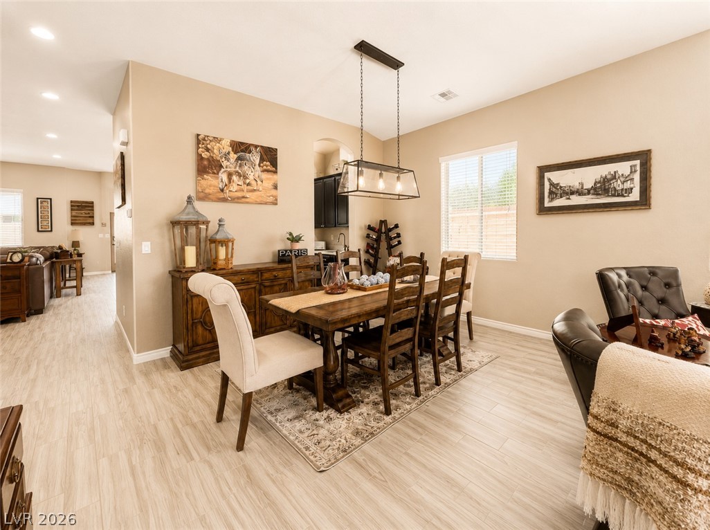 9724 University Ridge Avenue Las Vegas, NV 89149 - Photo 8 of 61 An inviting dining area features light wood-look flooring and a contemporary chandelier.
