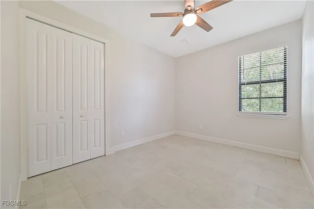 an empty room with windows and fan