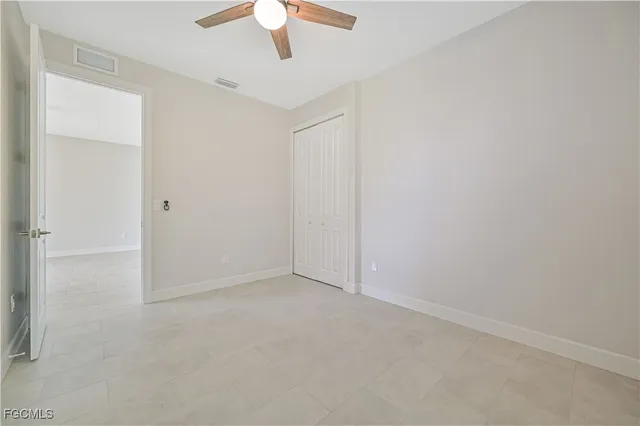an empty room with a chandelier fan