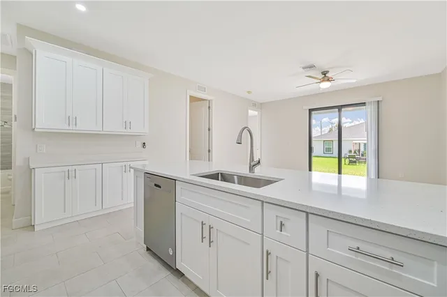 a kitchen with white cabinets and a window