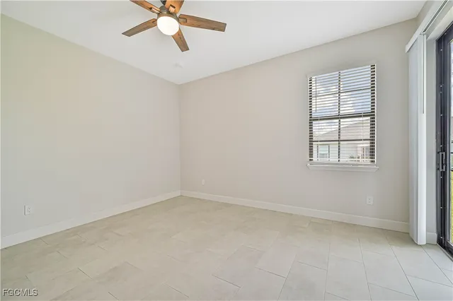 an empty room with a window and a fan
