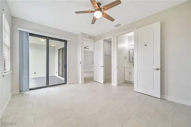 an empty room with closet and a ceiling fan
