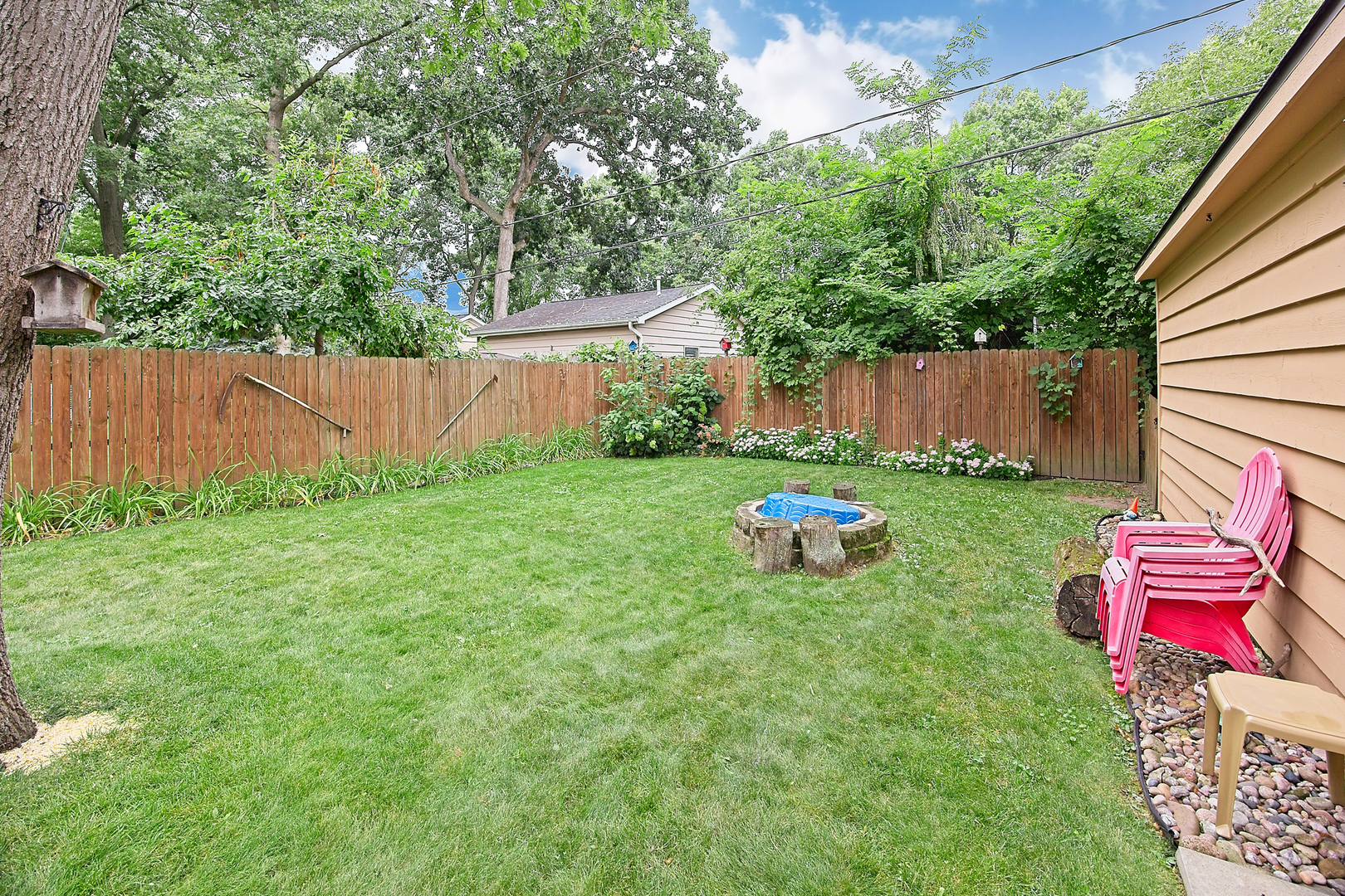 902 Wilson Court Zion, IL 60099 - Photo 11 of 30 a backyard of a house with table and chairs wooden fence