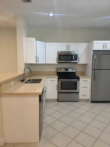a kitchen with a sink a stove and refrigerator