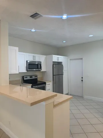a kitchen with stainless steel appliances a refrigerator and a stove top oven