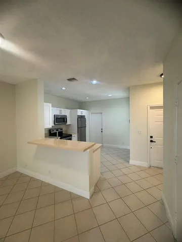 a view of kitchen with stainless steel appliances a refrigerator and a stove top oven