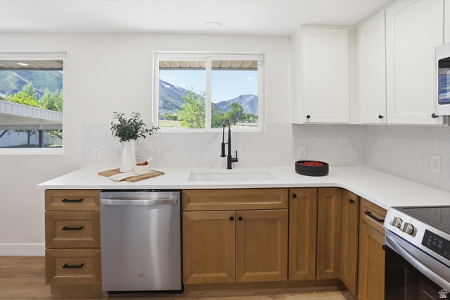 810 East Maple Street Mapleton, UT 84664 - Photo 10 of 49 Modern kitchen featuring two-tone cabinetry, white countertops, a stainless steel dishwasher, and a deep single-basin sink with a matte black faucet