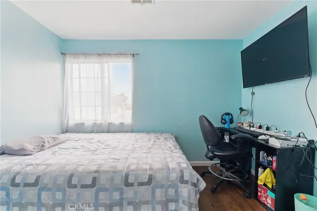 a bedroom with a bed and a flat tv screen on a dresser