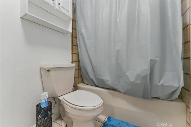 a bathroom with a toilet and a shower curtain