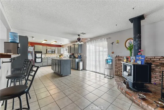 a kitchen with stainless steel appliances kitchen island granite countertop a stove a sink a dining table and chairs with the cabinets