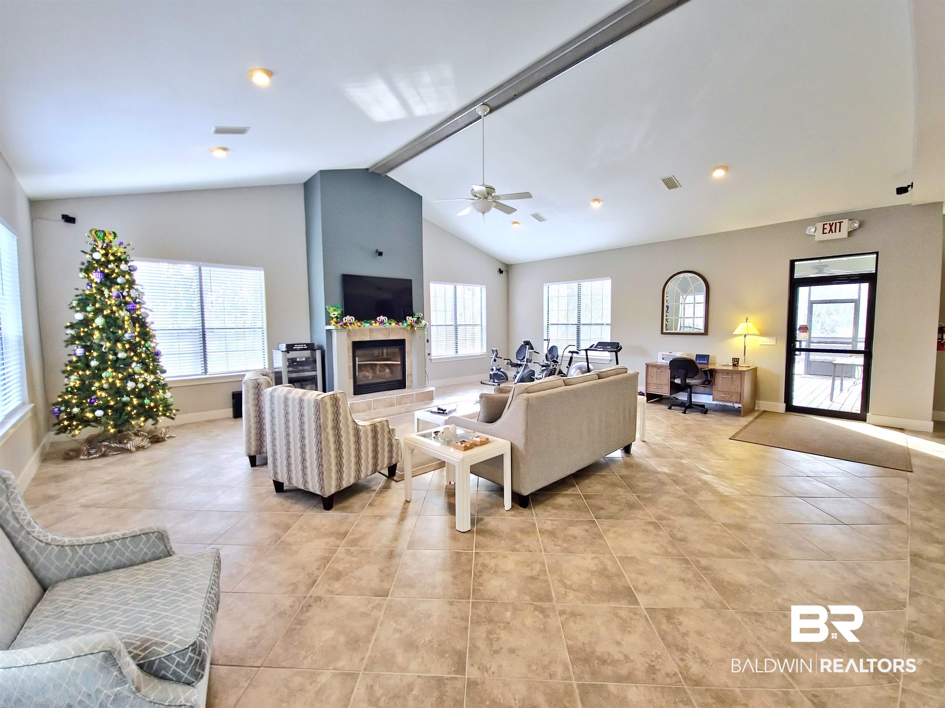 4650 Griffith Marina Road, Unit 12 Orange Beach, AL 36561 - Photo 25 of 34 Living area with vaulted ceiling, ceiling fan, a glass covered fireplace, healthy amount of natural light, and light tile patterned flooring