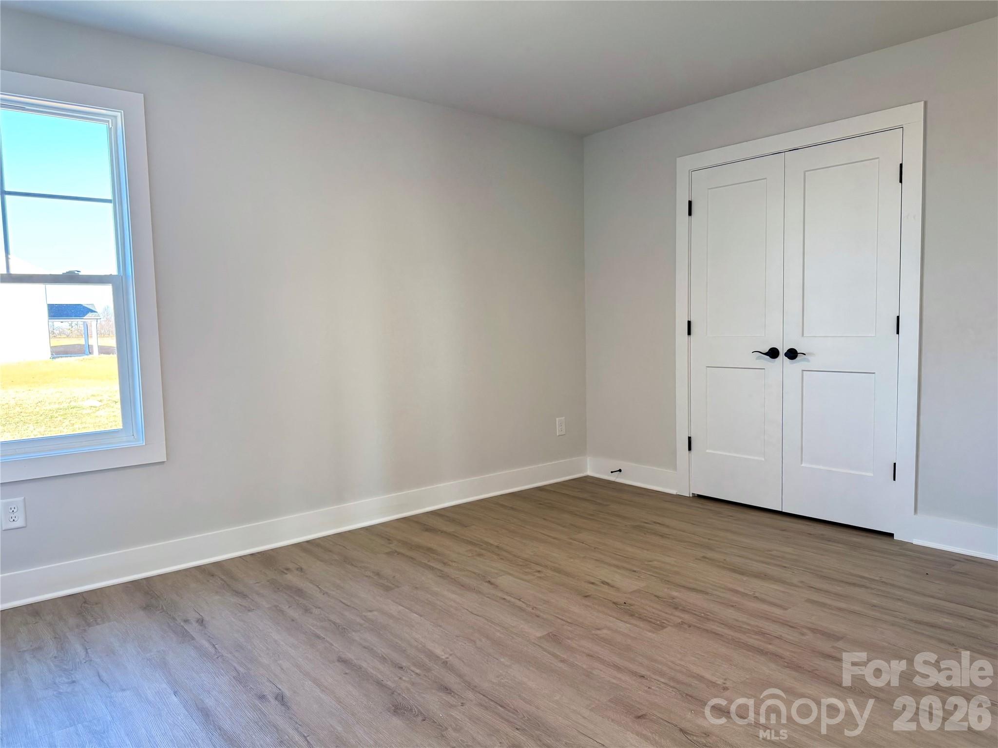 2440 Sandy Springs Road Mocksville, NC 27028 - Photo 11 of 15 a view of an empty room with wooden floor and a window