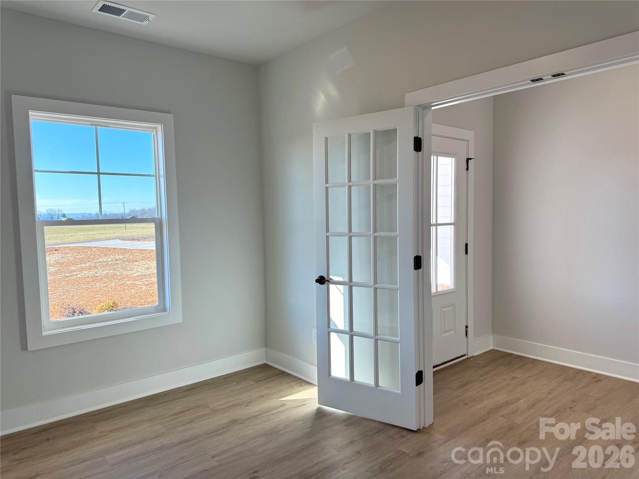 2440 Sandy Springs Road Mocksville, NC 27028 - Photo 4 of 15 a view of an empty room with wooden floor and a window
