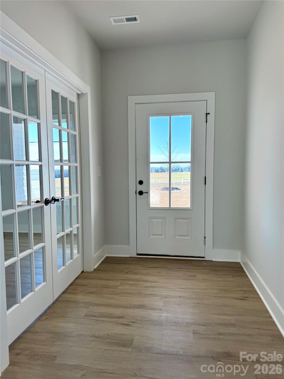 2440 Sandy Springs Road Mocksville, NC 27028 - Photo 5 of 15 an empty room with wooden floor and windows