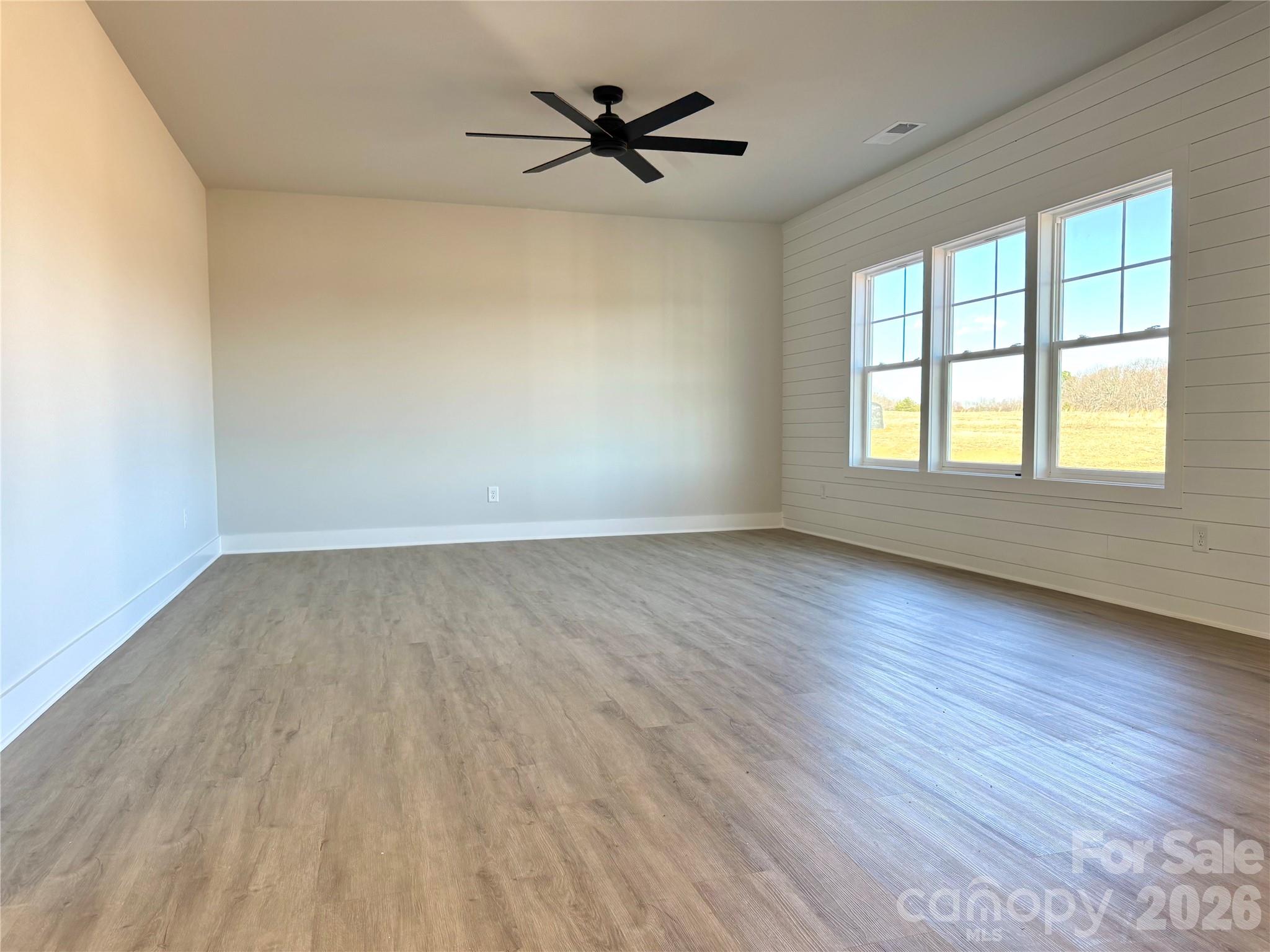 2440 Sandy Springs Road Mocksville, NC 27028 - Photo 6 of 15 an empty room with wooden floor and windows