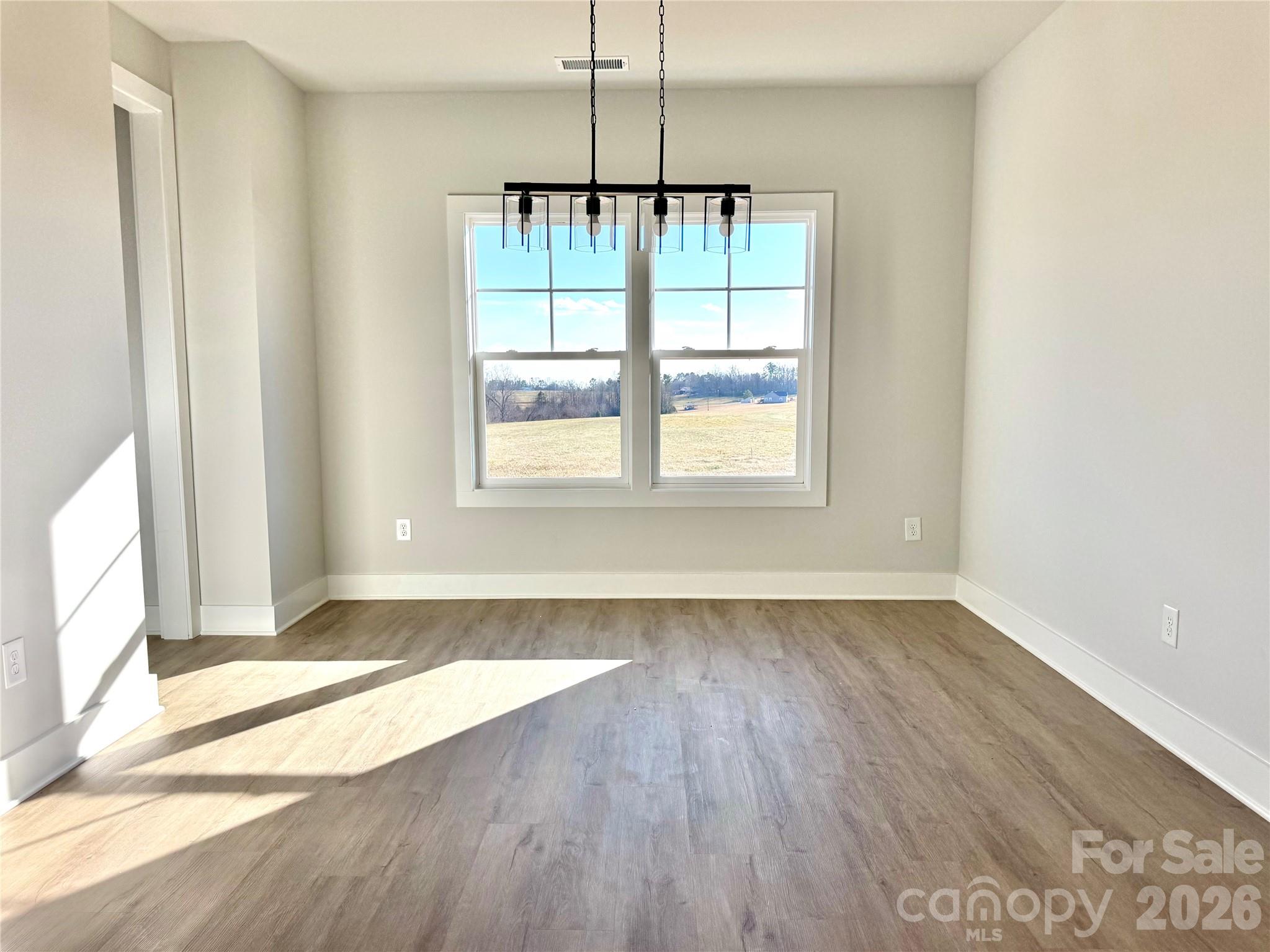 2440 Sandy Springs Road Mocksville, NC 27028 - Photo 7 of 15 an empty room with wooden floor and windows