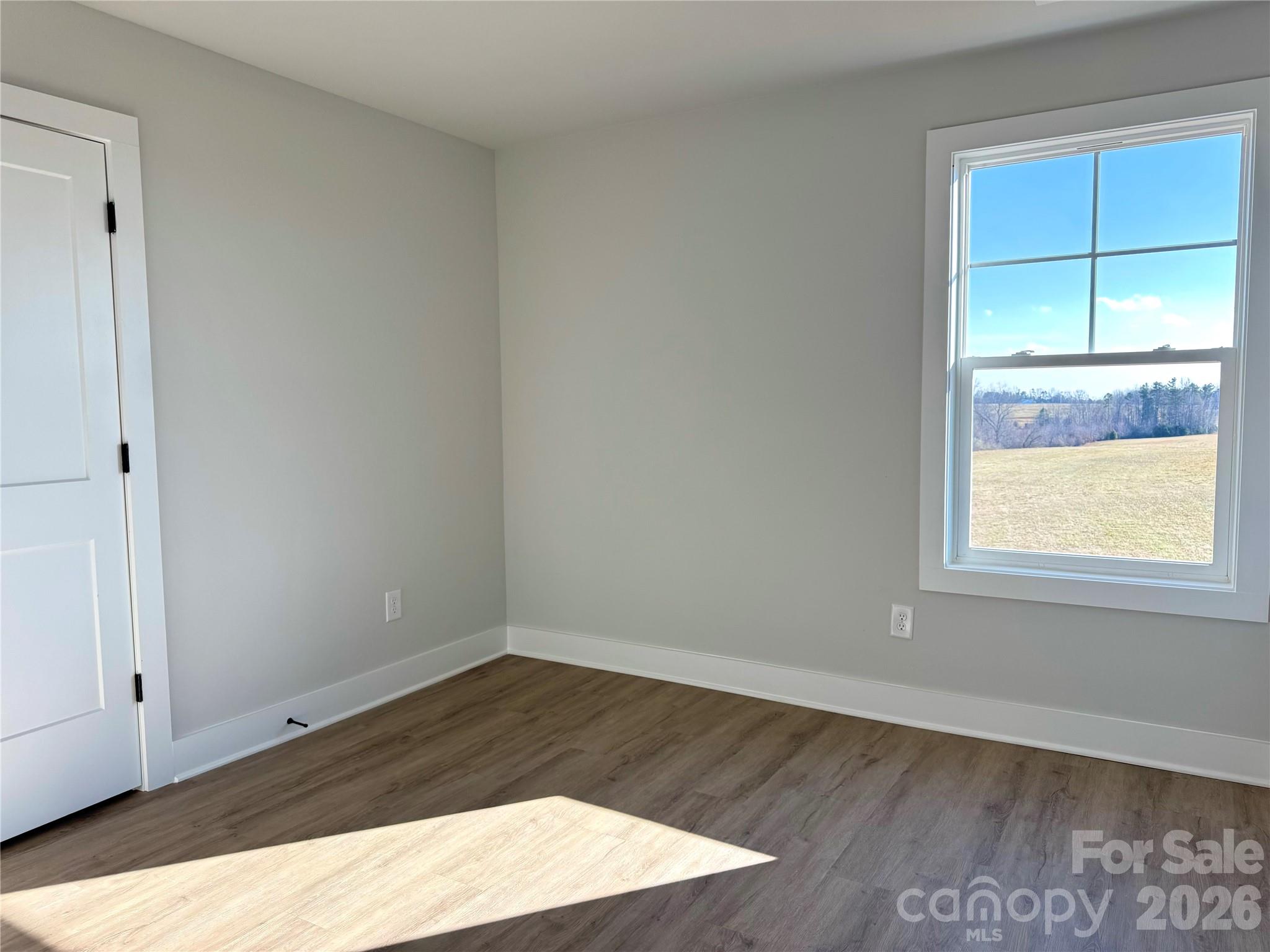 2440 Sandy Springs Road Mocksville, NC 27028 - Photo 10 of 15 an empty room with wooden floor and windows