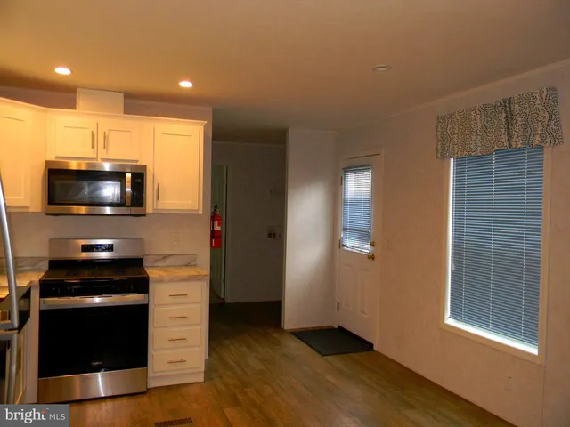 a kitchen with granite countertop a stove and a microwave