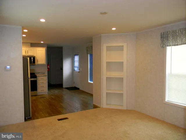 an empty room with closet and windows
