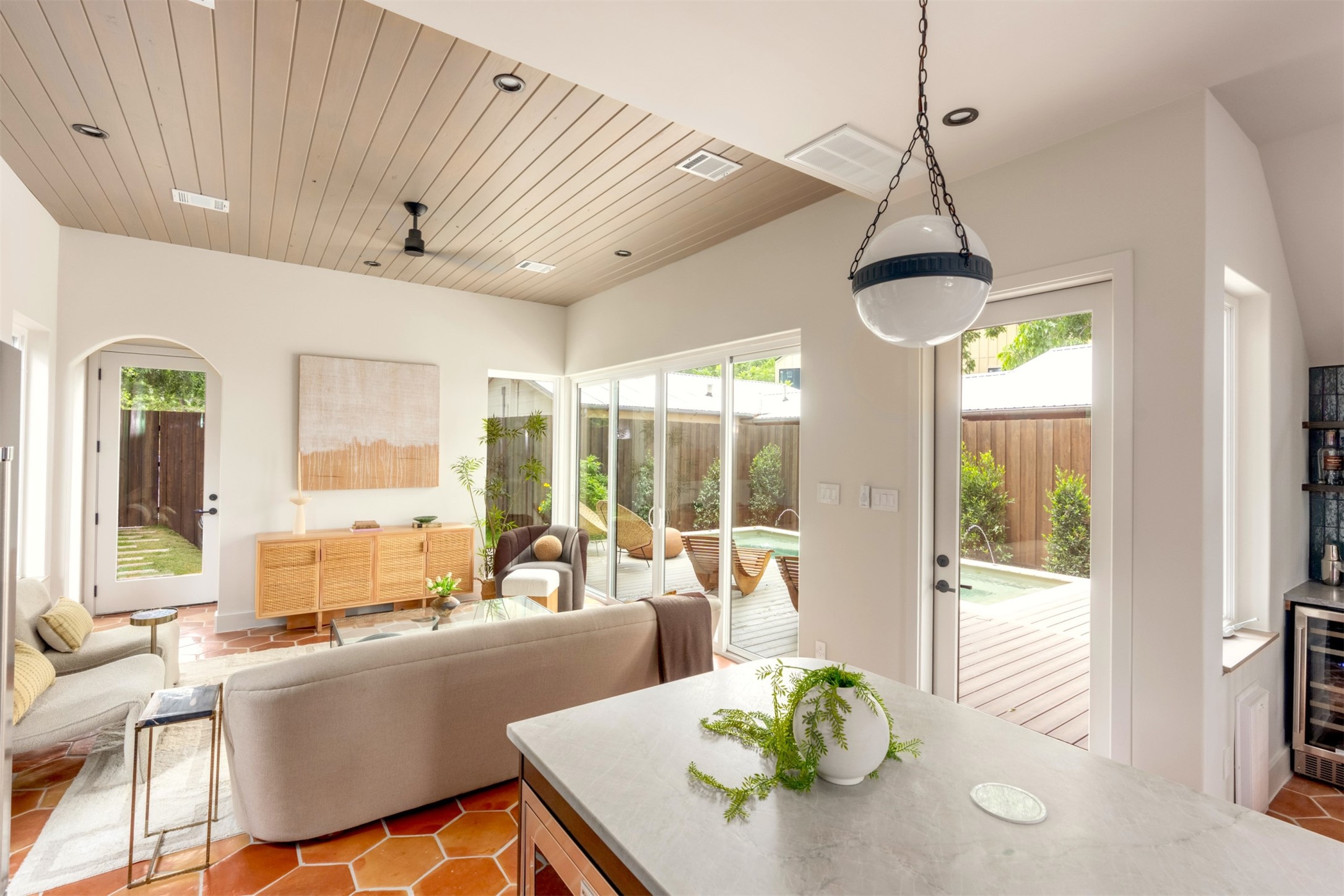 4713 Bolm Road Austin, TX 78702 - Photo 13 of 40 Open-concept living area featuring a wood-plank ceiling with recessed lighting, hexagonal terracotta flooring, and extensive glass doors providing abundant natural light