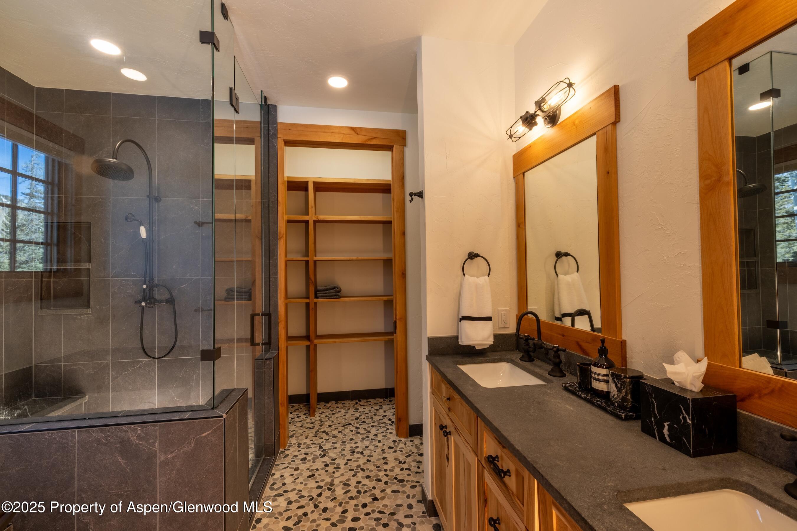4901 Cimarron Mountain Road Montrose, CO 81403 - Photo 12 of 39 a bathroom with a double vanity sink a mirror and a shower