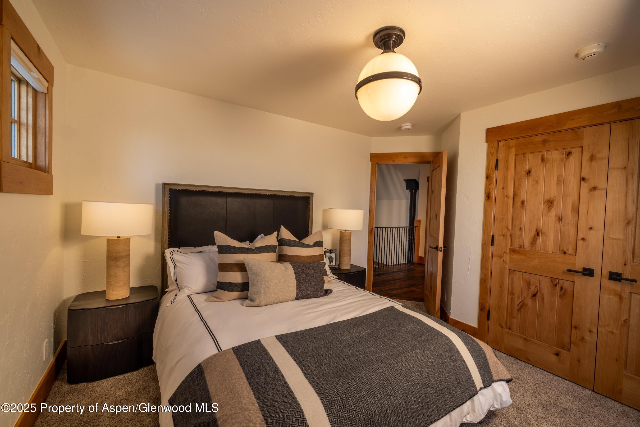 4901 Cimarron Mountain Road Montrose, CO 81403 - Photo 15 of 39 a bedroom with a bed and a chandelier