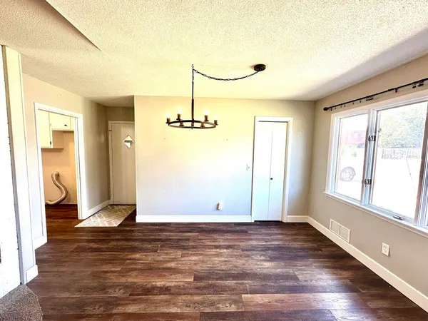 a view of empty room with wooden floor and window