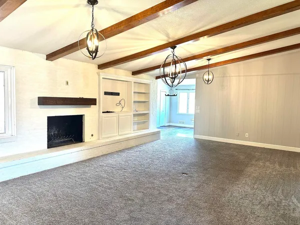 a view of empty room with a fireplace and fan