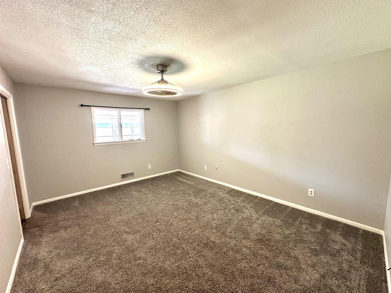 819 Holliday Plainview, TX 79072 - Photo 22 of 38 an empty room with windows and chandelier fan
