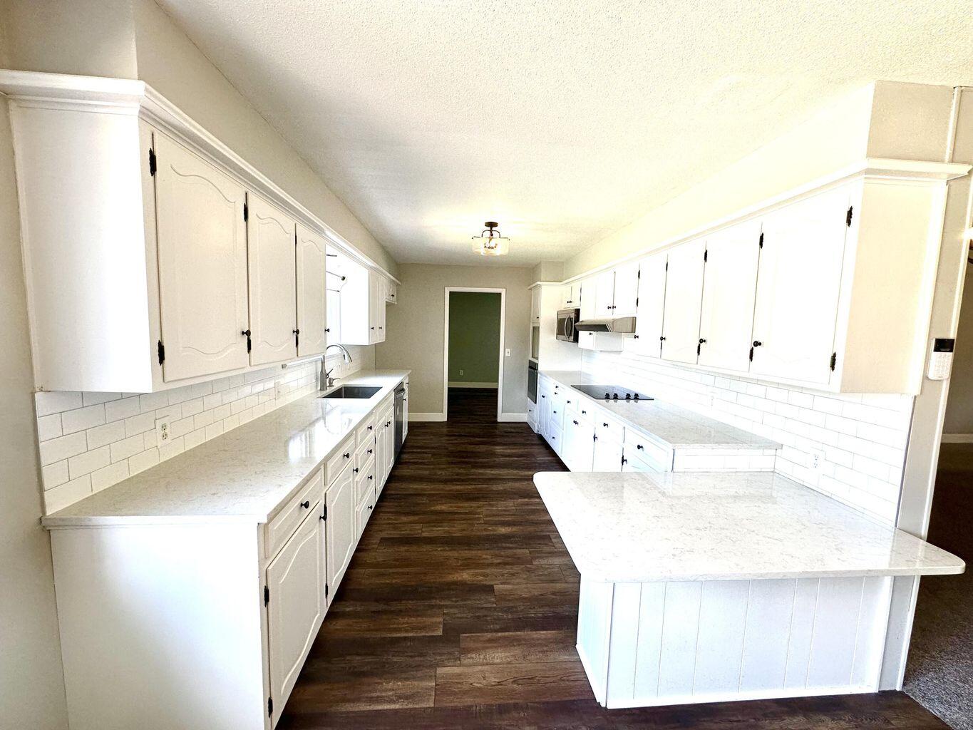 819 Holliday Plainview, TX 79072 - Photo 10 of 38 a large white kitchen with a large window