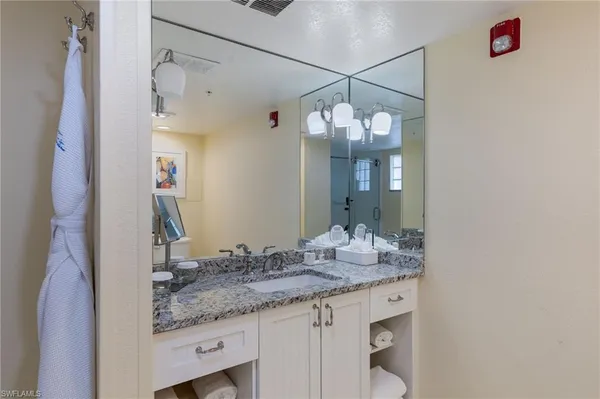 a bathroom with a granite countertop sink and a mirror