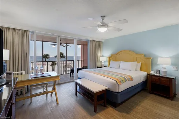 a bedroom with a bed a table and a flat screen tv