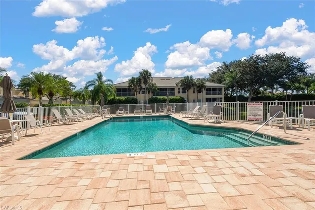 a view of a swimming pool and lounge chairs in patio