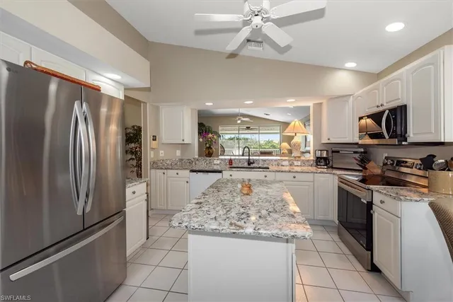 a kitchen with stainless steel appliances granite countertop a refrigerator a stove top oven a sink and cabinets