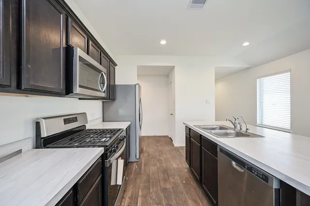 a kitchen with stainless steel appliances granite countertop a sink stove and cabinets