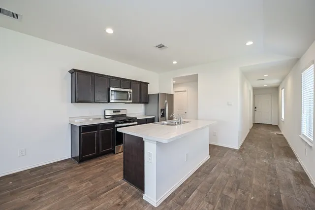 a kitchen with stainless steel appliances a sink stove and refrigerator