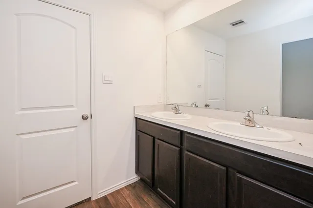 a bathroom with a double vanity sink and a mirror