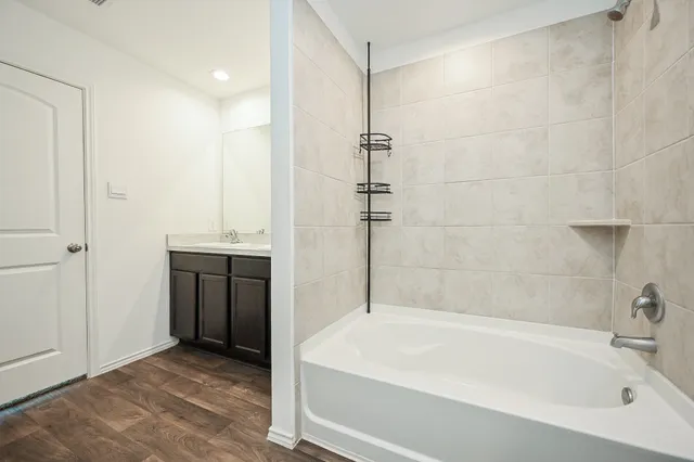 a white bath tub sitting in a bathroom and shower