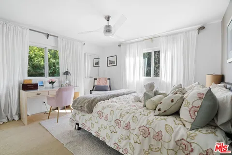 a bedroom with a bed and large windows