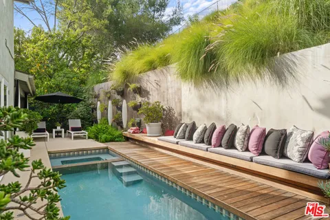 a view of swimming pool with outdoor seating and plants