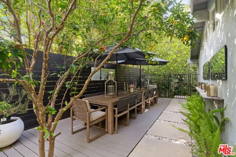 a view of a chairs and table under an umbrella in the patio