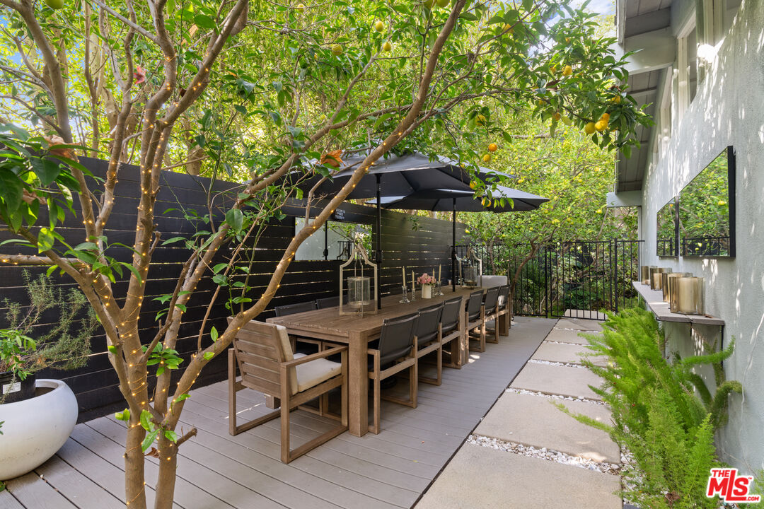 9767 Apricot Lane Beverly Hills, CA 90210 - Photo 27 of 29 a view of a chairs and table under an umbrella in the patio
