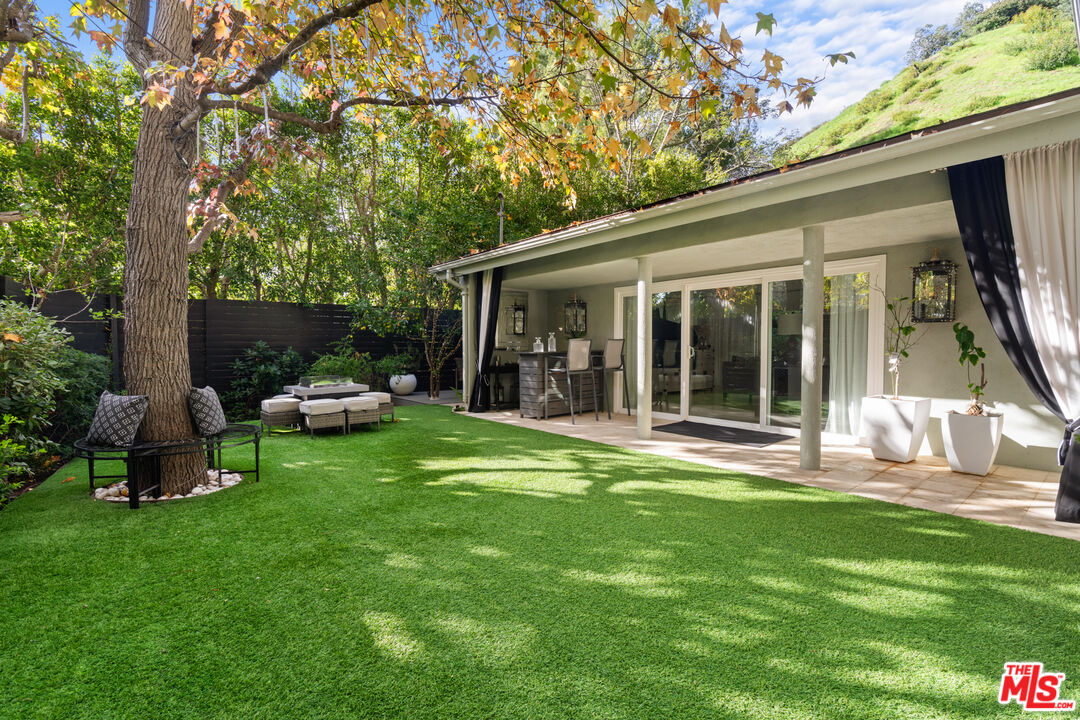 9767 Apricot Lane Beverly Hills, CA 90210 - Photo 6 of 29 a view of a chair and table in backyard of the house
