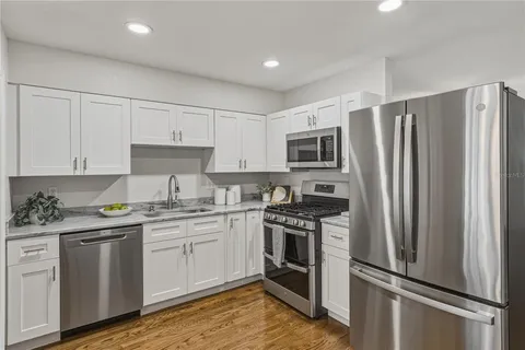 a kitchen with stainless steel appliances a refrigerator a stove a sink a center island and cabinets