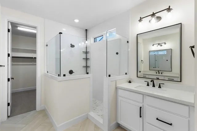 a bathroom with a double vanity sink mirror and shower