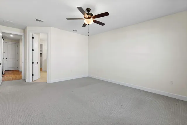 an empty room with closet and ceiling fan